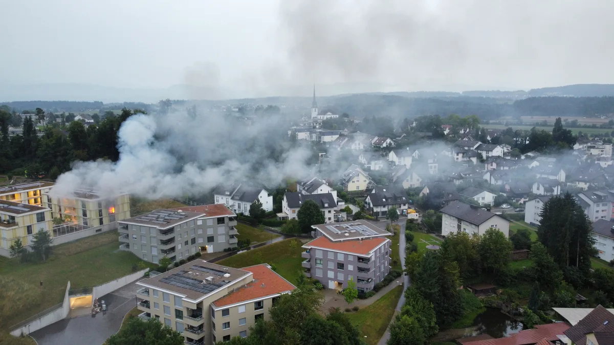 Rauch steigt aus einem Mehrfamilienhaus.